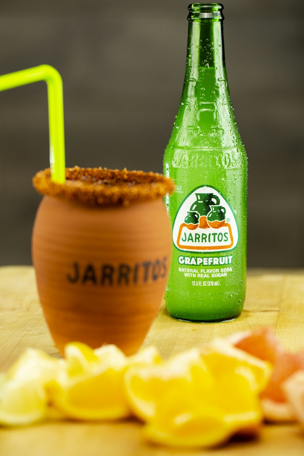 green and brown bottle beside brown wooden cup