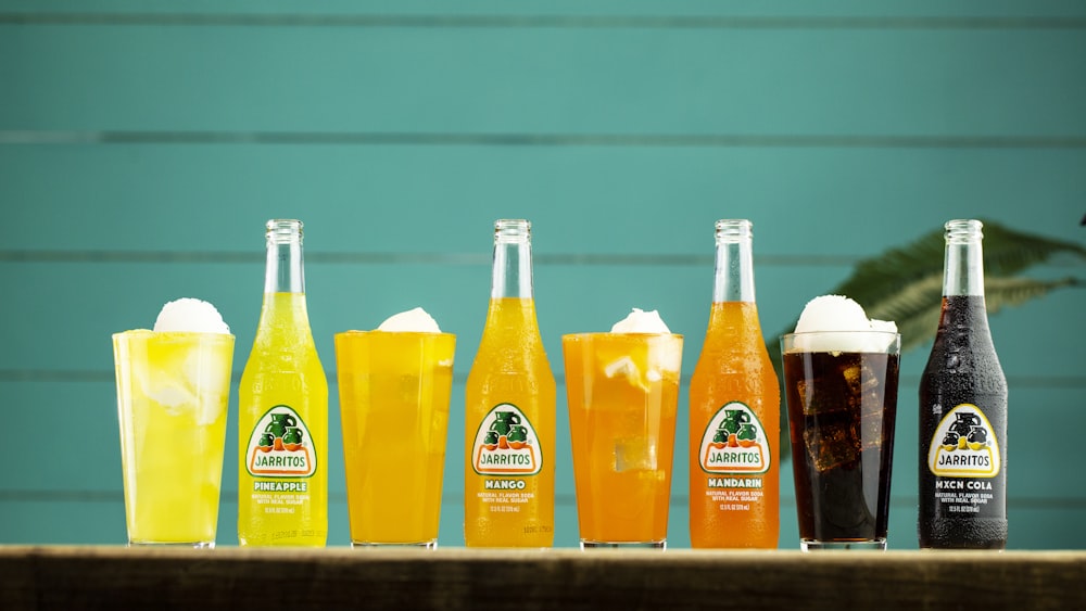 three orange juice bottles on shelf