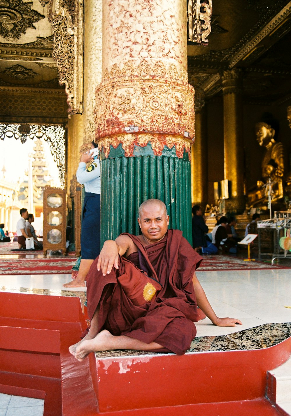 man in brown thobe sitting on red and gold chair