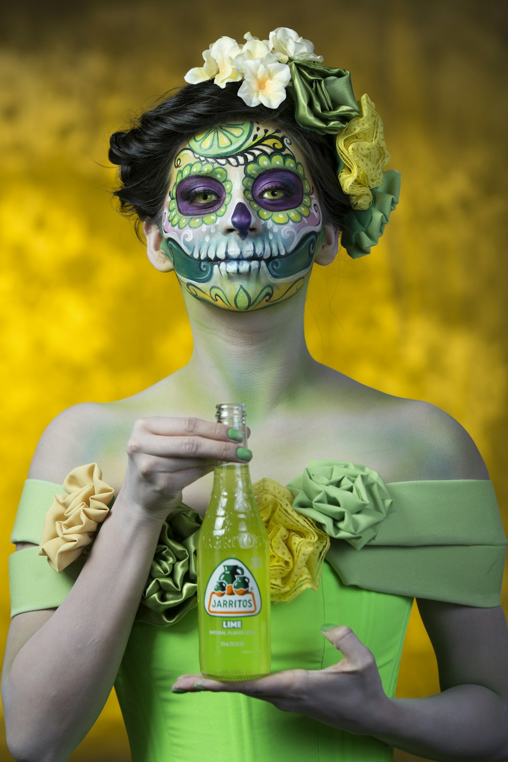 woman in green dress holding glass bottle