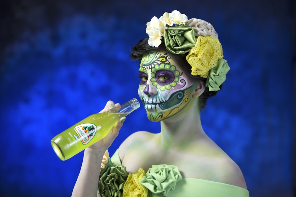 person with green face mask holding green bottle