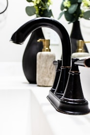 A modern soap dispenser with a matte finish placed beside a neatly folded white towel on a clean bathroom shelf.