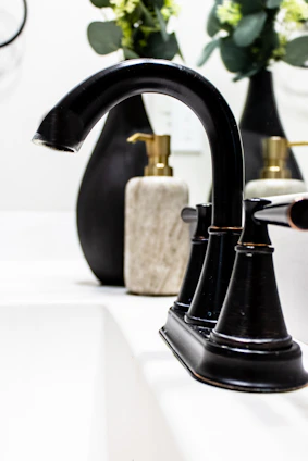 A close-up of a rich wood vanity and sleek matte black faucet showcasing craftsmanship and quality.