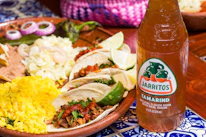 a plate of food and a bottle of beer on a table