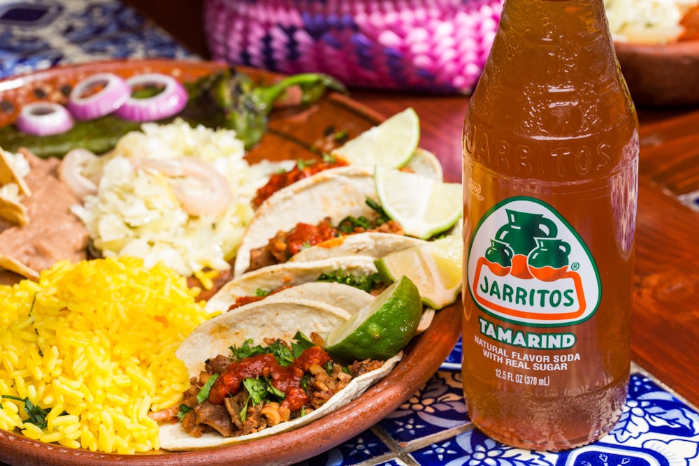 a plate of food and a bottle of beer on a table