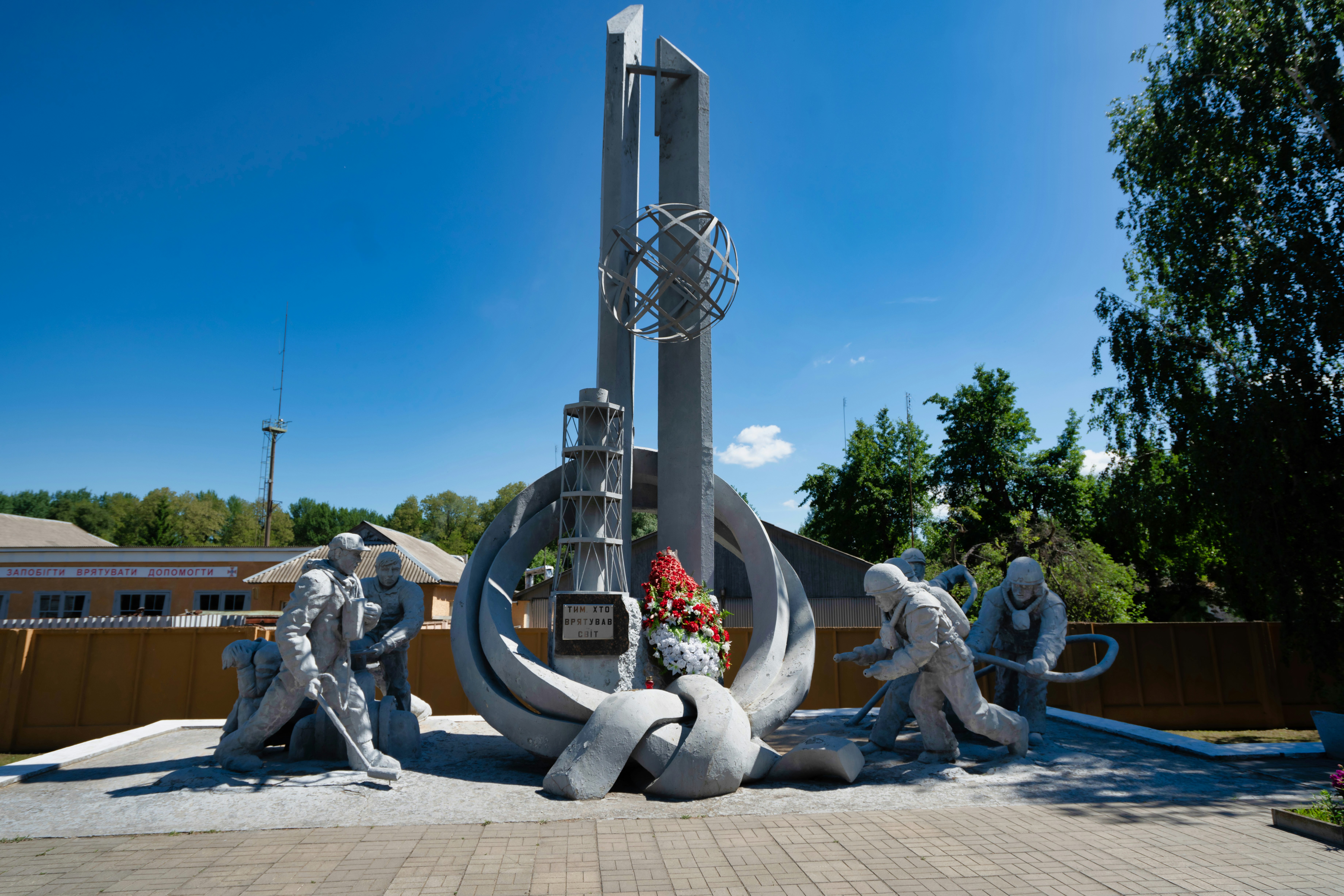 people sitting on concrete bench near gray concrete statue during daytime