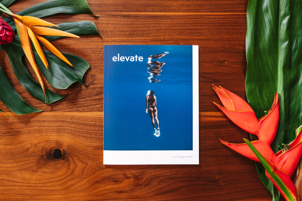 a book on a table with flowers and leaves