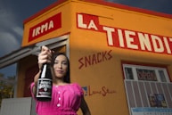woman in pink long sleeve shirt holding black bottle