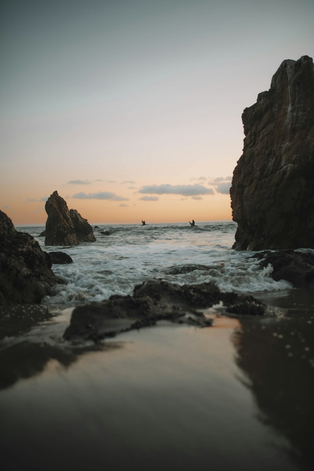 Formation rocheuse brune sur la mer au coucher du soleil