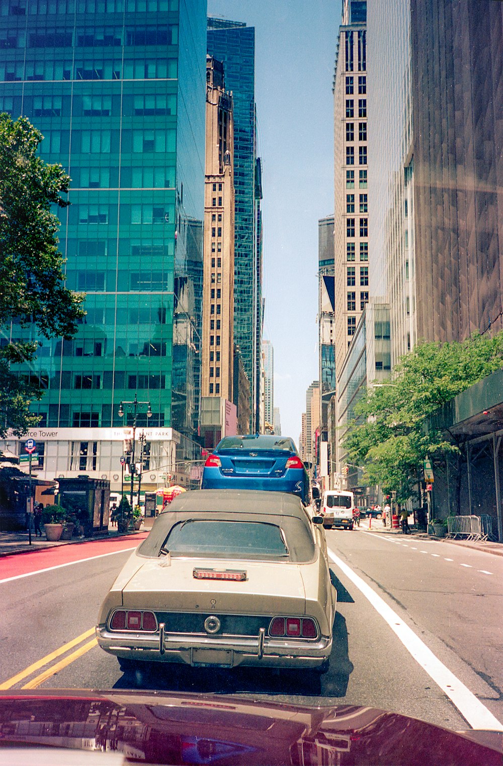 cars on road near high rise buildings during daytime