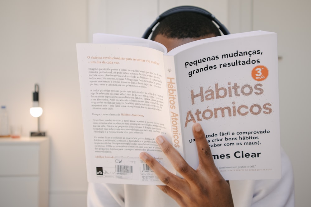 a man reading a book with headphones on his head