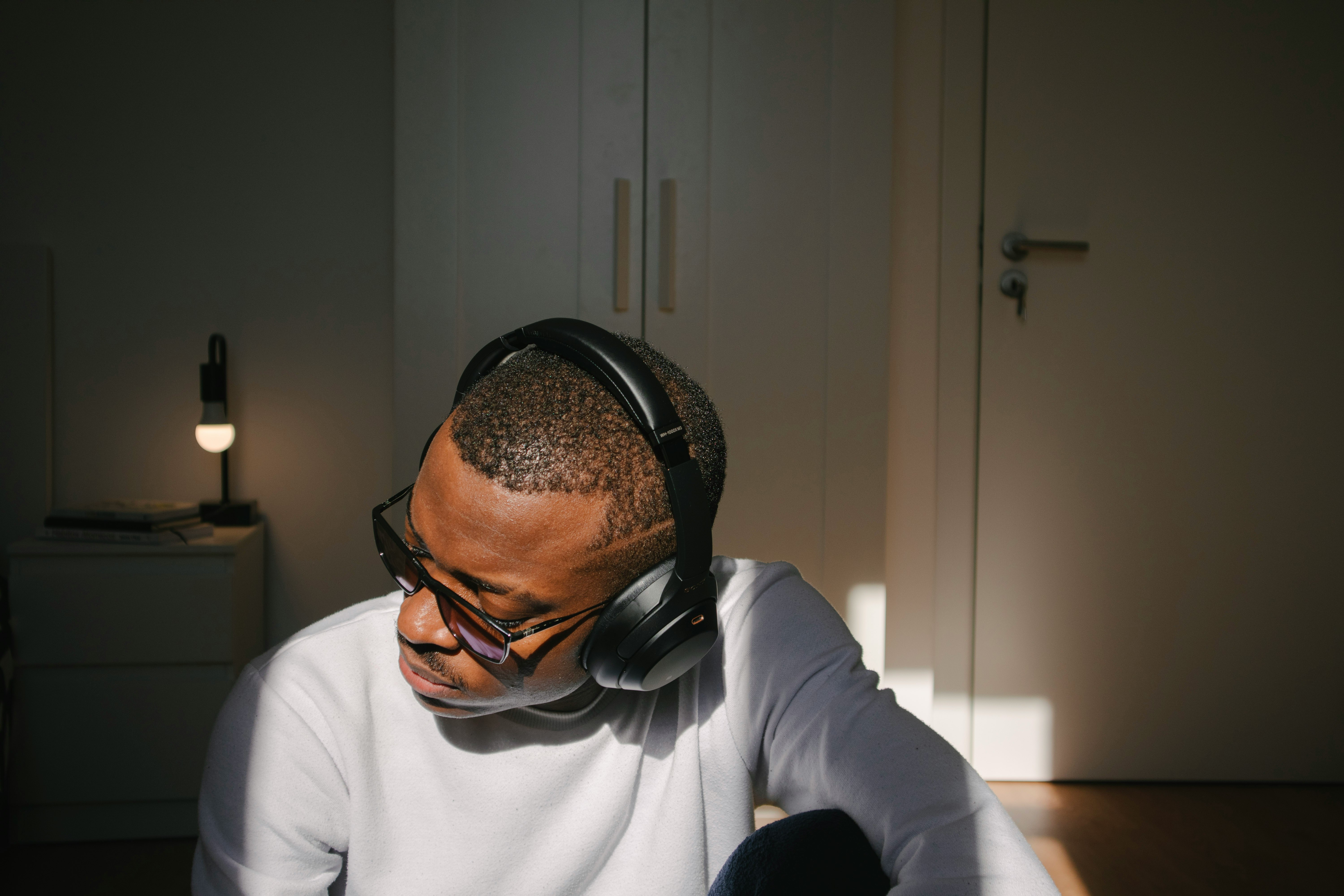 man in white long sleeve shirt wearing black headphones