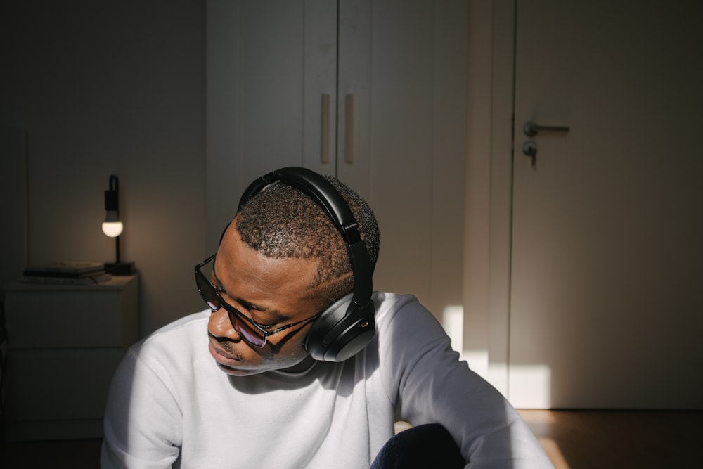 man in white long sleeve shirt wearing black headphones