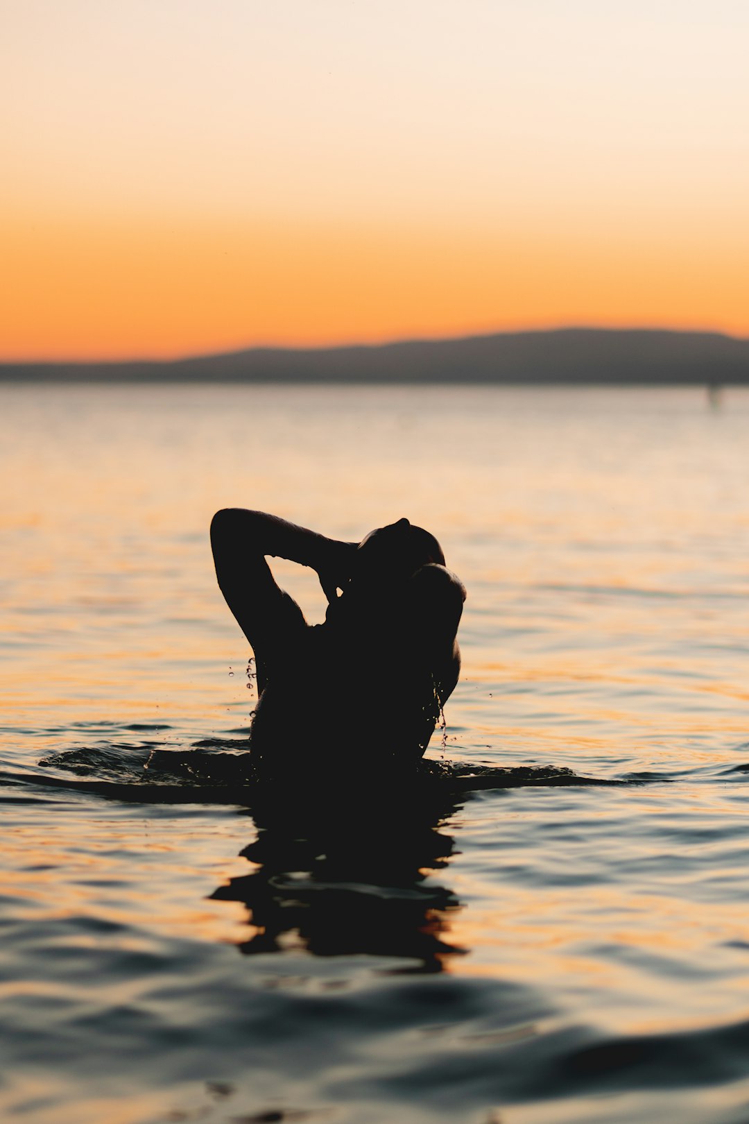 woman in water during sunset