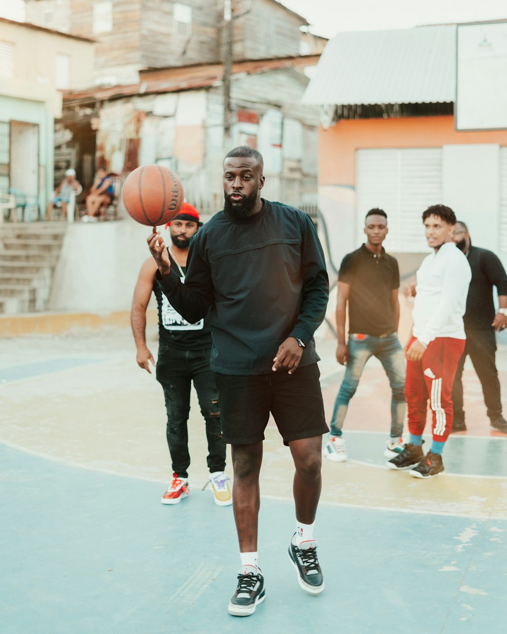 man in black polo shirt holding basketball