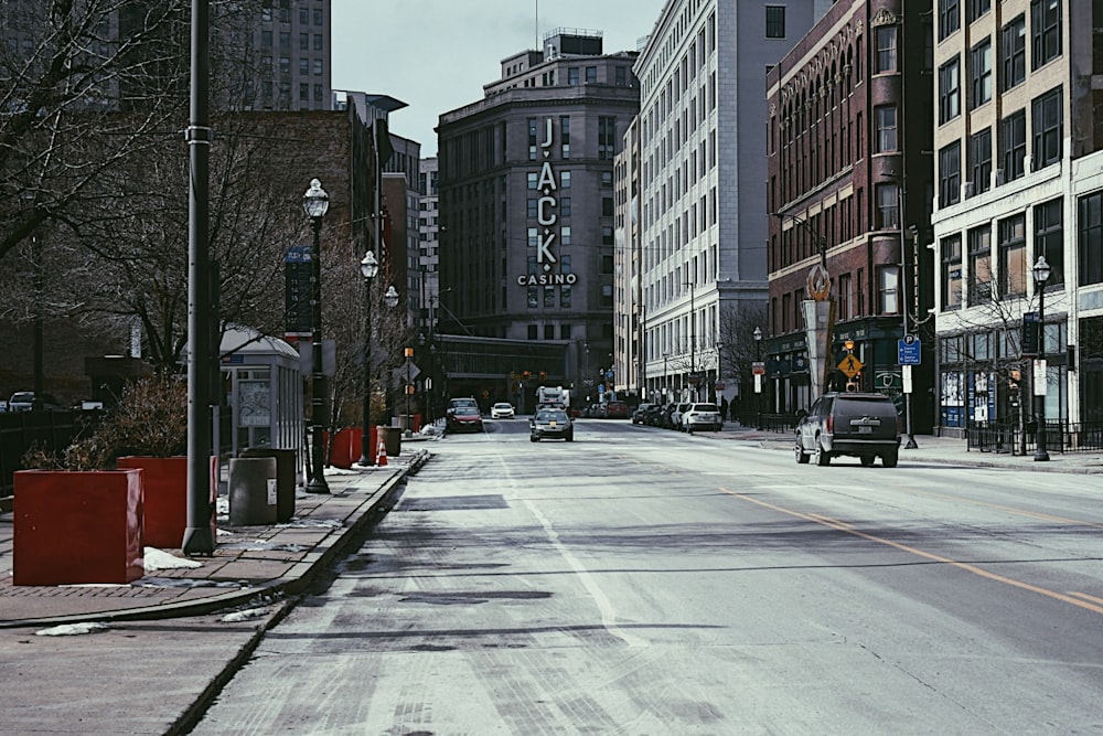 cars parked on side of the road near high rise buildings during daytime