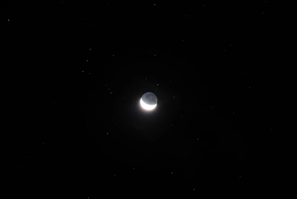 A serene night sky filled with stars and a glowing crescent moon, symbolizing cosmic insight.