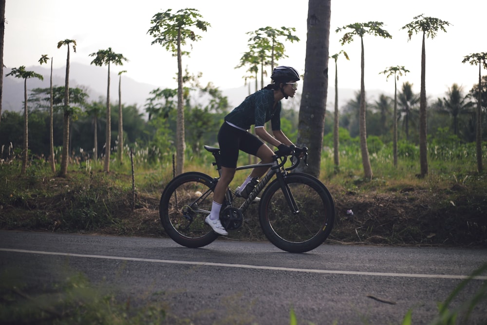 man in black t-shirt riding bicycle on road during daytime