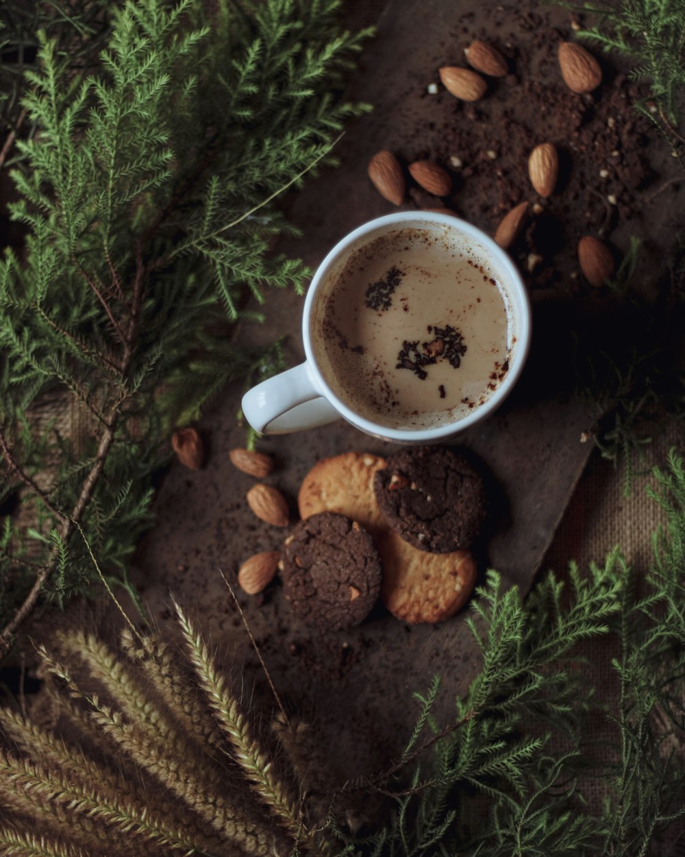 white ceramic mug with coffee on brown pine cone