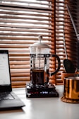 clear glass mug on black and silver laptop computer