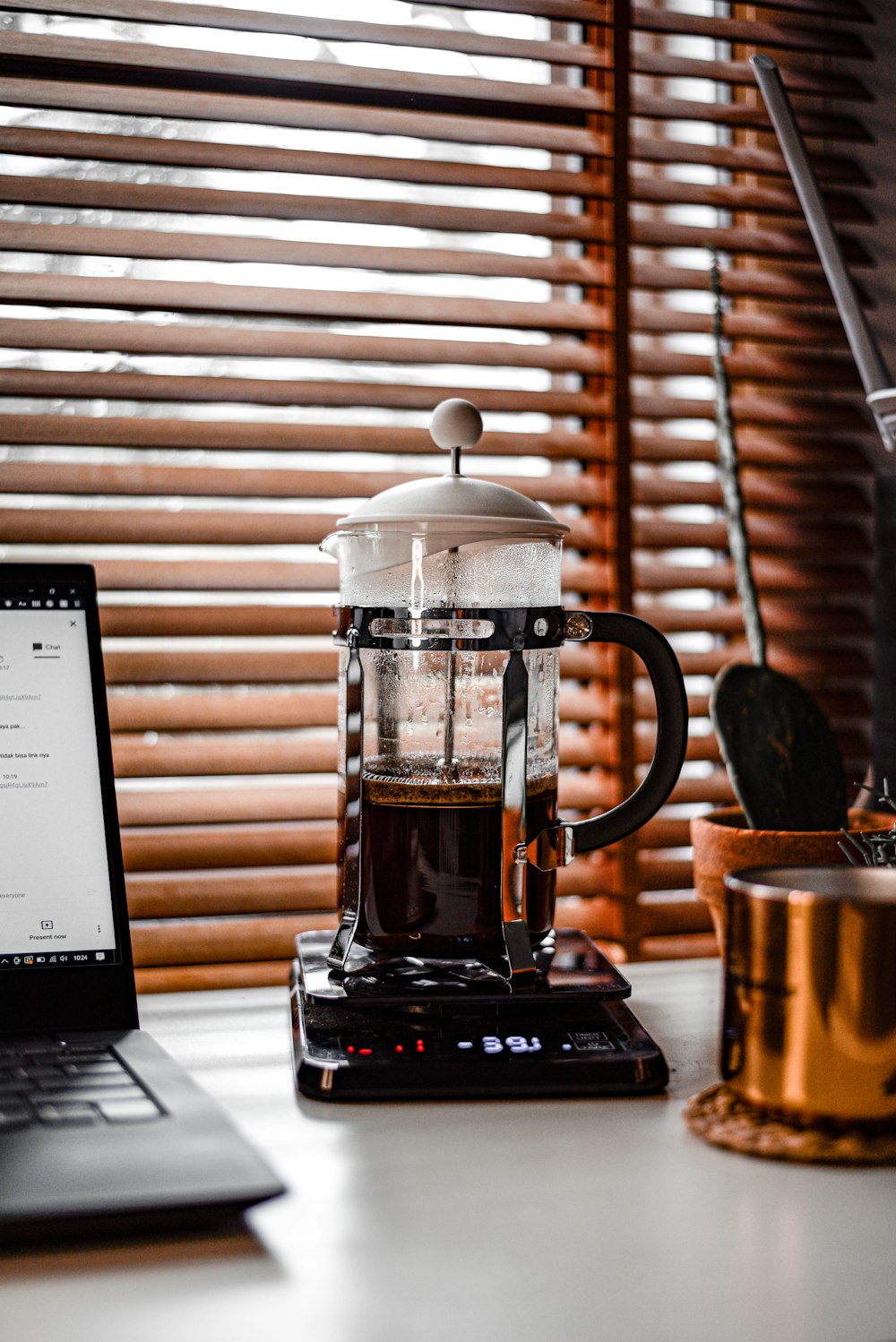 clear glass mug on black and silver laptop computer