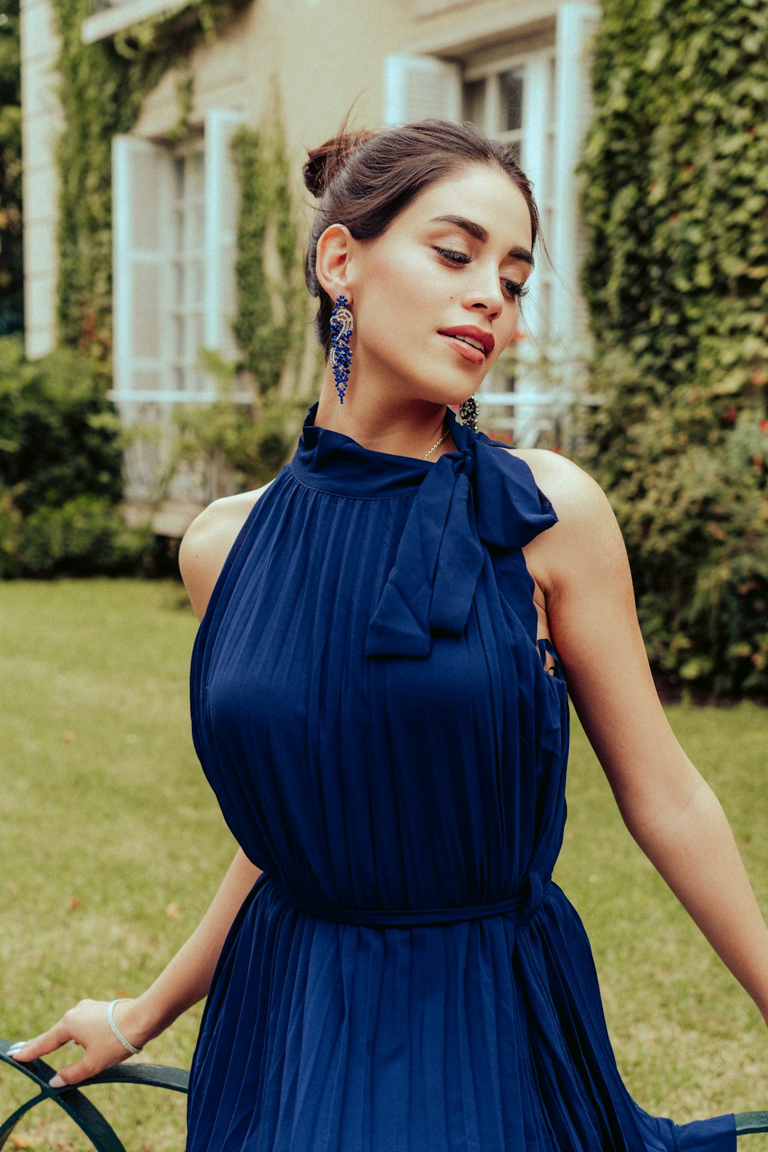 woman in blue sleeveless dress standing on green grass field during daytime