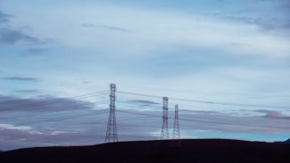 black electric tower under white clouds