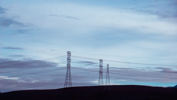 black electric tower under white clouds
