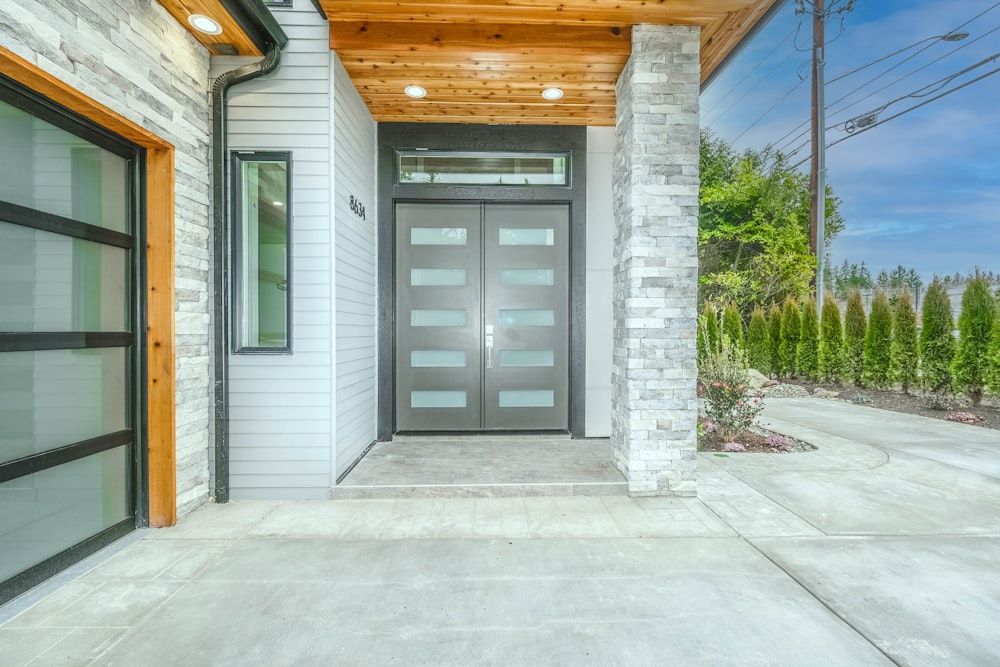 gray wooden door near green plants during daytime