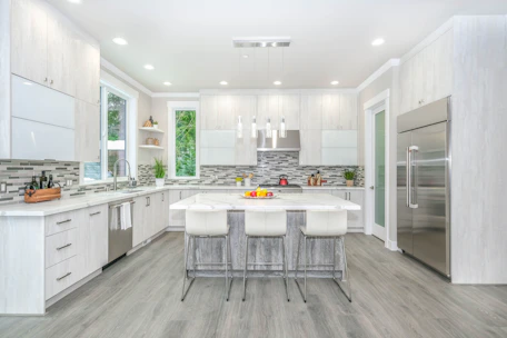 A bright, modern kitchen featuring sleek cabinetry and a spacious island with warm lighting.