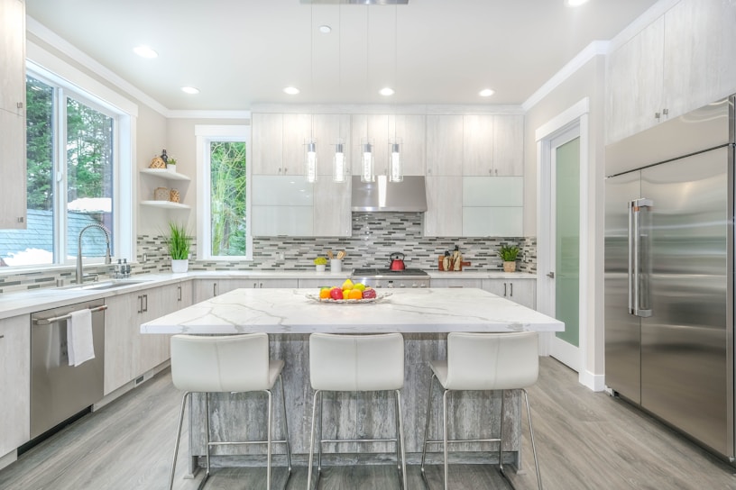 Modern kitchen island with sleek white quartz countertop and turquoise accents in a Loja home.