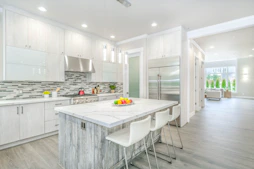 Remodeled kitchen with backsplash and island.