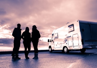 silhouette of 3 men standing near white van