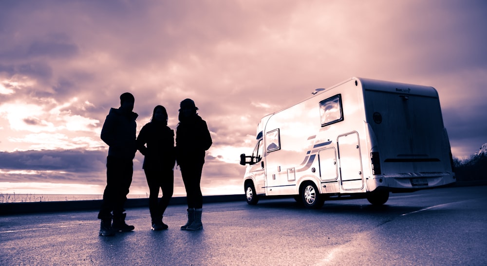 silhouette of 3 men standing near white van