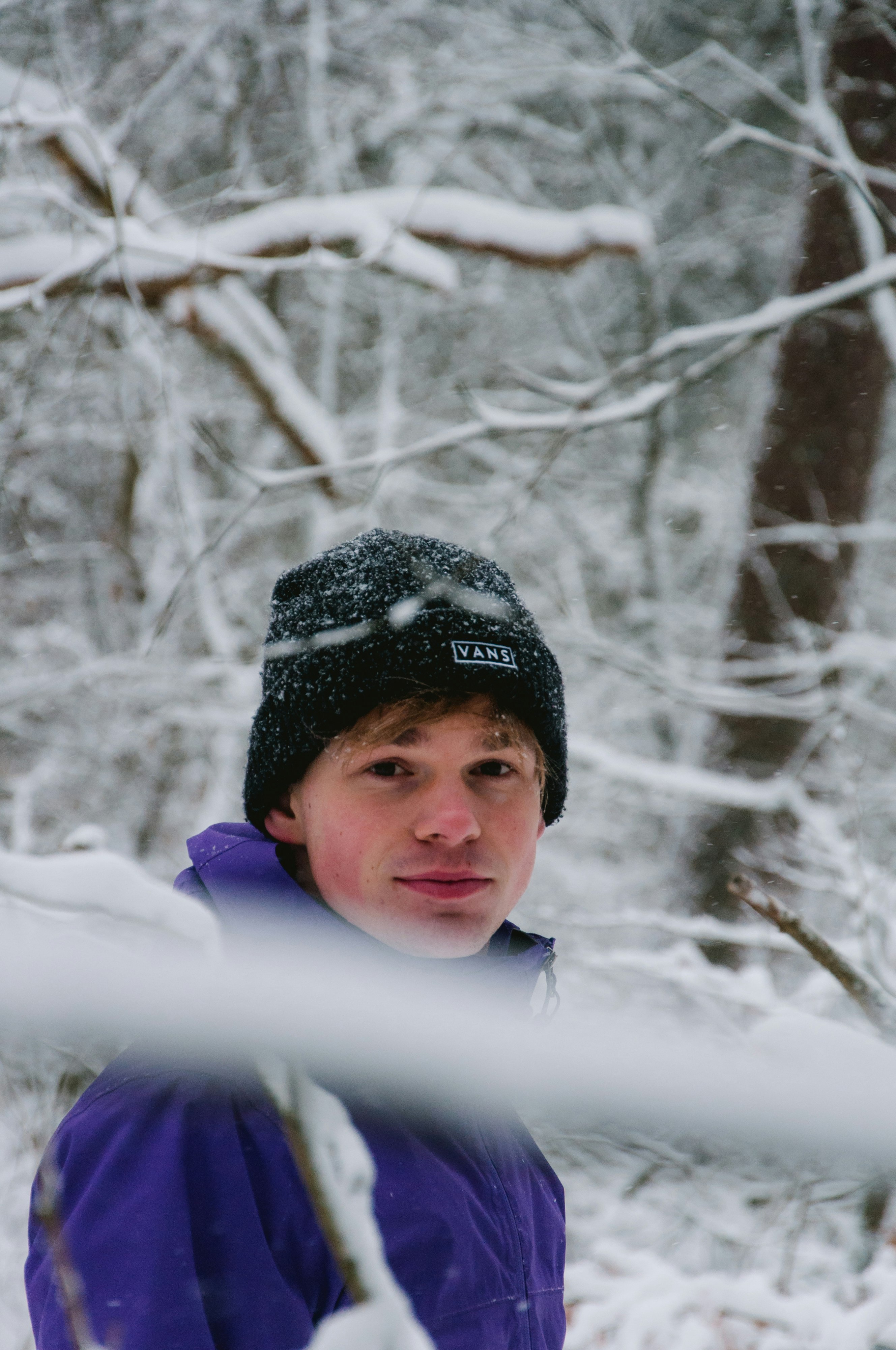 boy in blue hoodie standing on snow covered ground during daytime