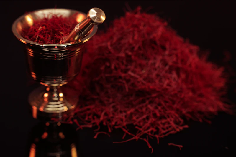 Saffron threads beside a brass vessel