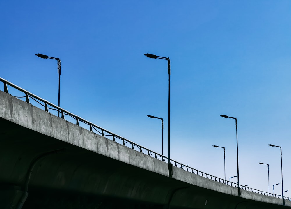 black metal post on gray concrete bridge under blue sky during daytime