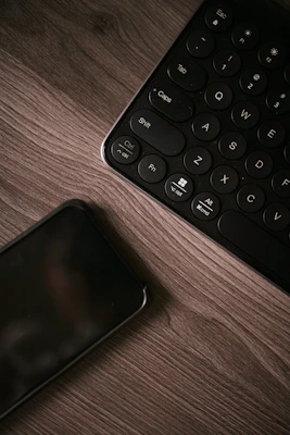 black and white keyboard on brown wooden table