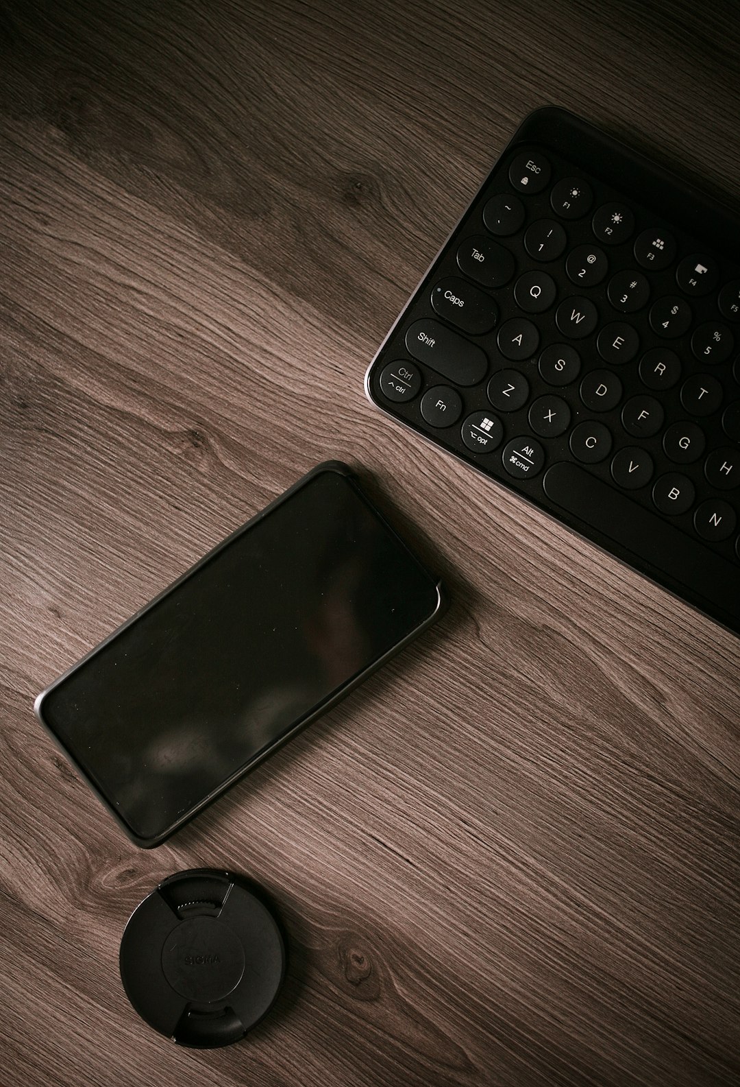 black iphone 7 beside black logitech cordless computer keyboard