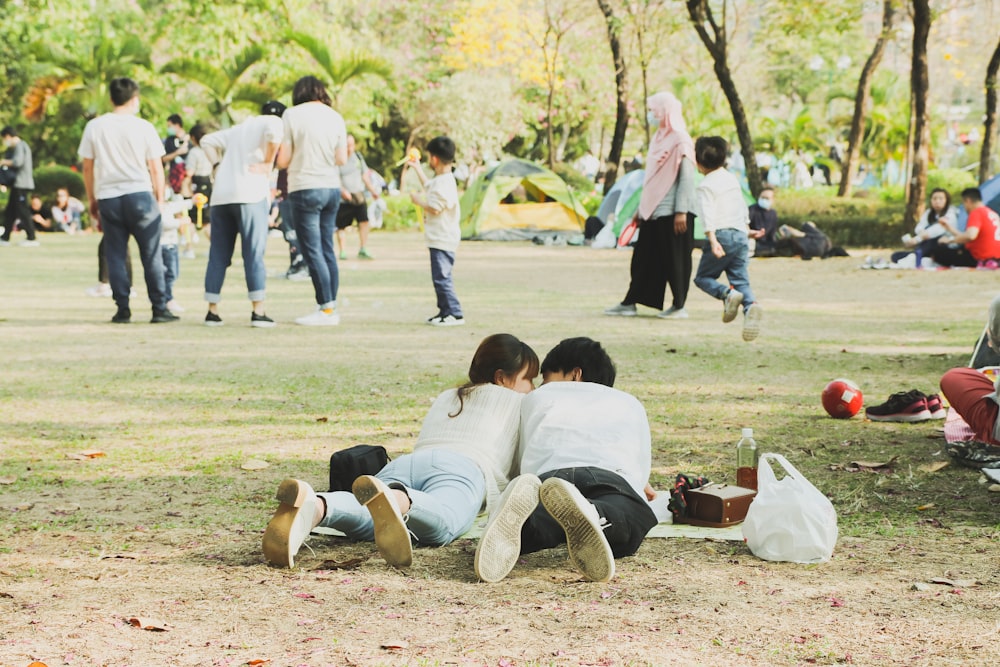 boy in white t-shirt and brown pants lying on ground