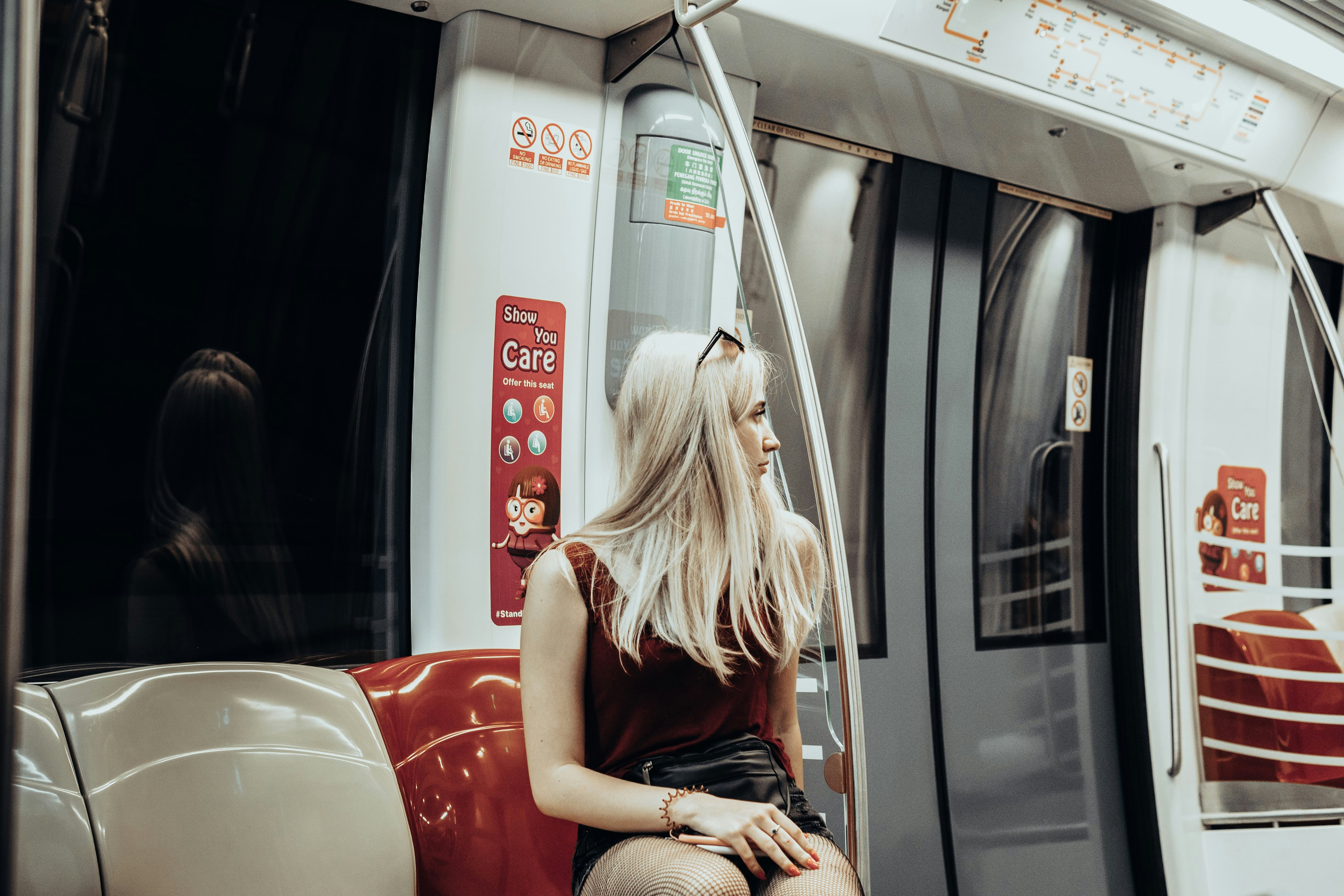 woman in black tank top sitting on red car