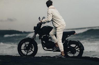 man in white robe riding black motorcycle