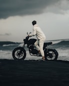 man in white robe riding black motorcycle