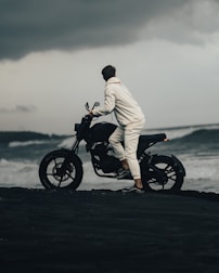 man in white robe riding black motorcycle