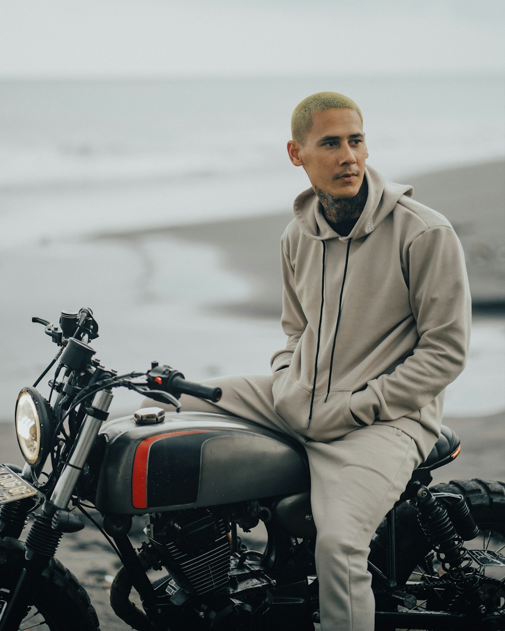 man in brown hoodie sitting on black motorcycle