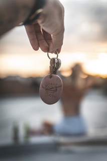 person holding heart shaped silver pendant