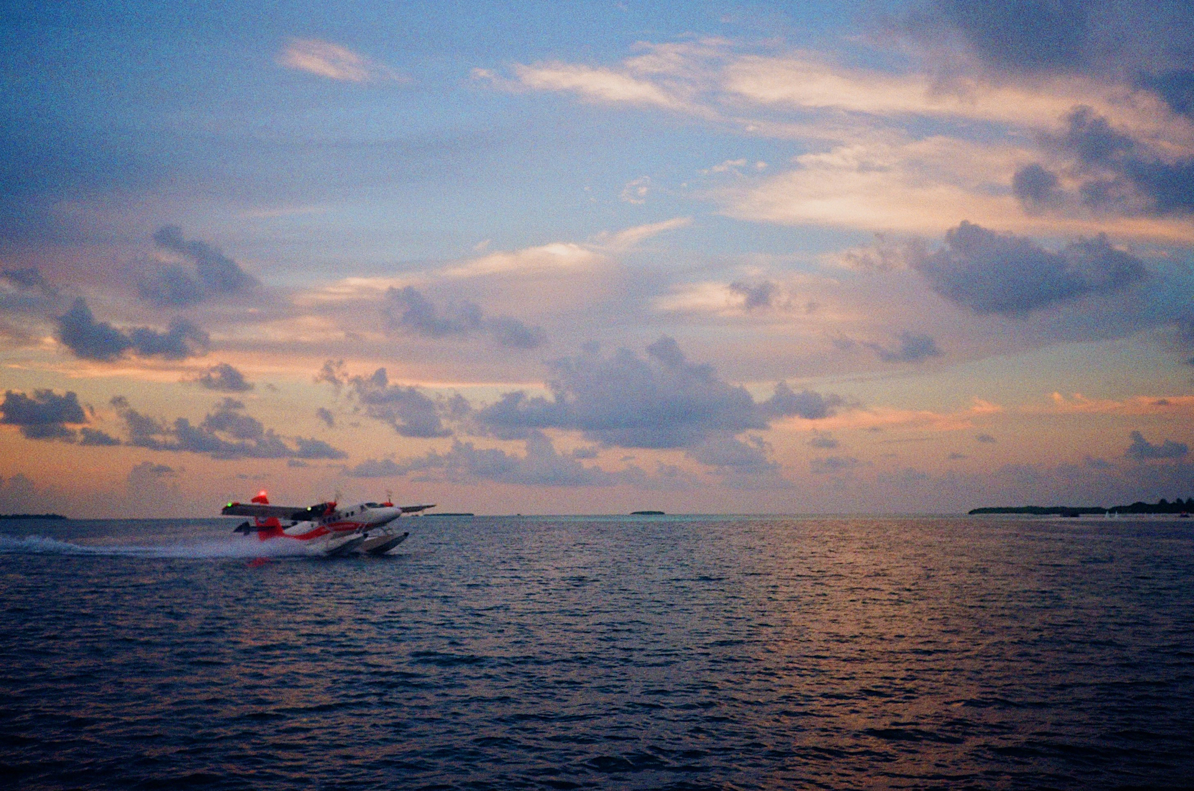 A seaplane taking off from the lagoon in the evening light, Maldives