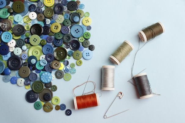 Close-up of various sewing supplies including threads and buttons.