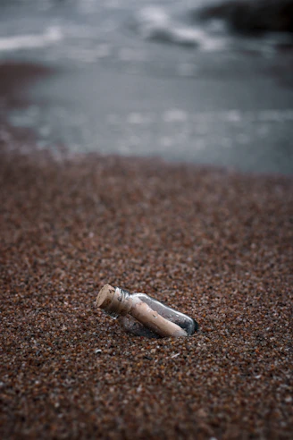 white and brown wooden tube on brown sand