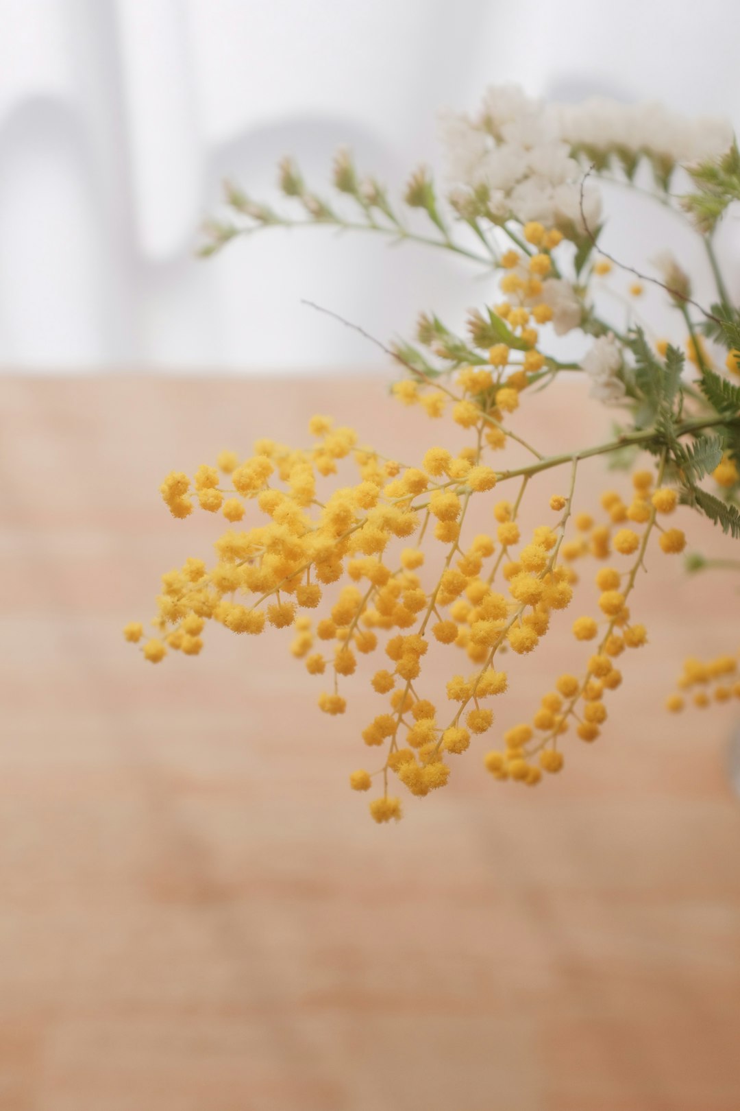 yellow flowers on brown wooden table